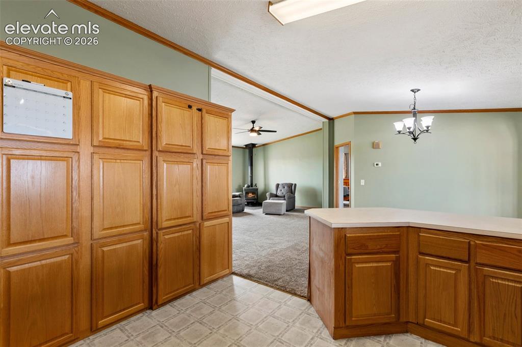 Image 24 of 45: Kitchen featuring extensive wood cabinetry, L-shaped countertop, recessed c