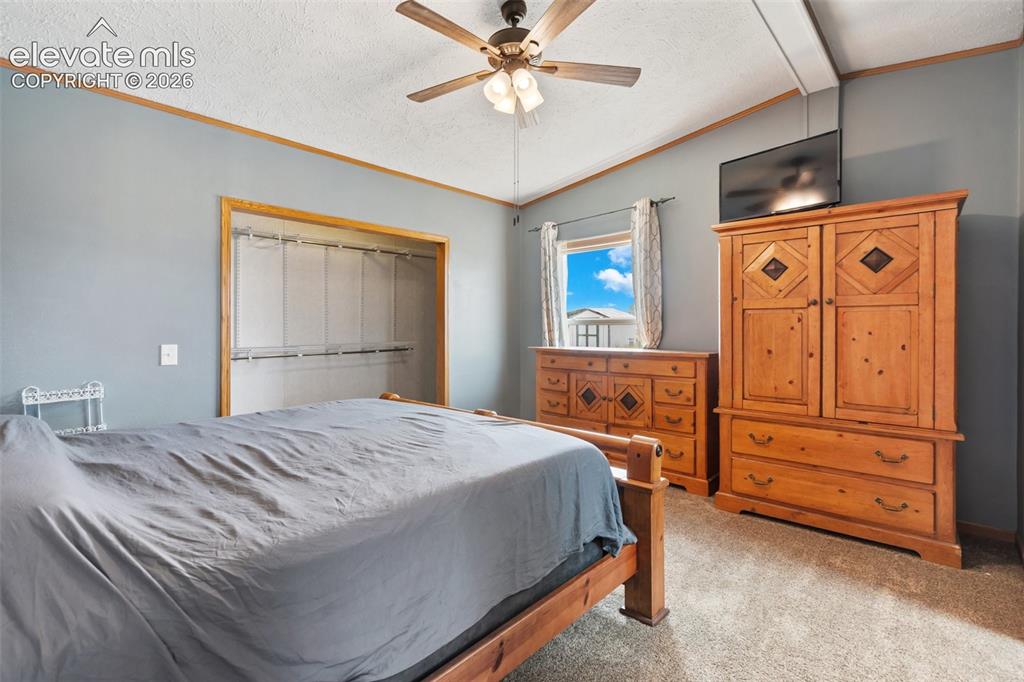 Image 29 of 45: Bedroom featuring a ceiling fan, light gray wall color, and carpet flooring