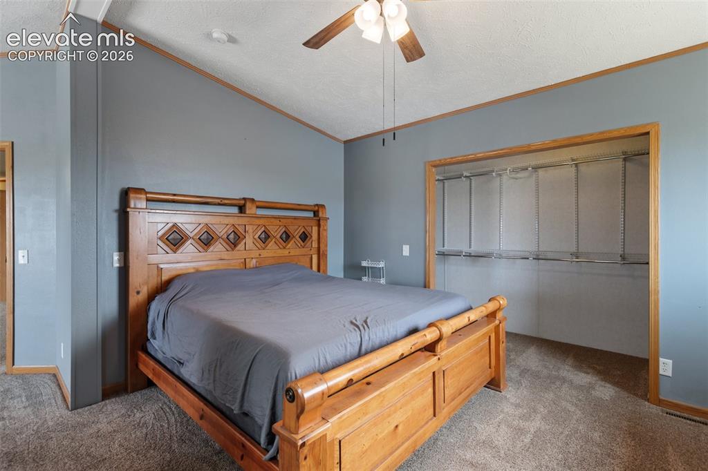 Image 30 of 45: Carpeted room with a vaulted ceiling and a ceiling fan
