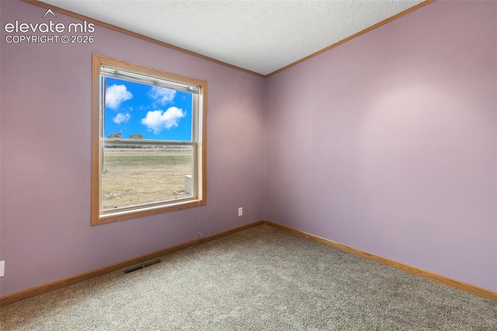 Image 37 of 45: Interior space featuring a large window with wood-finish trim, providing na