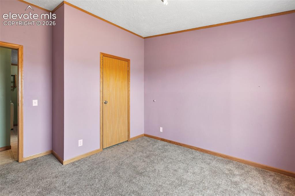 Image 38 of 45: Interior room featuring neutral wall color, wood-finish trim, and gray carp
