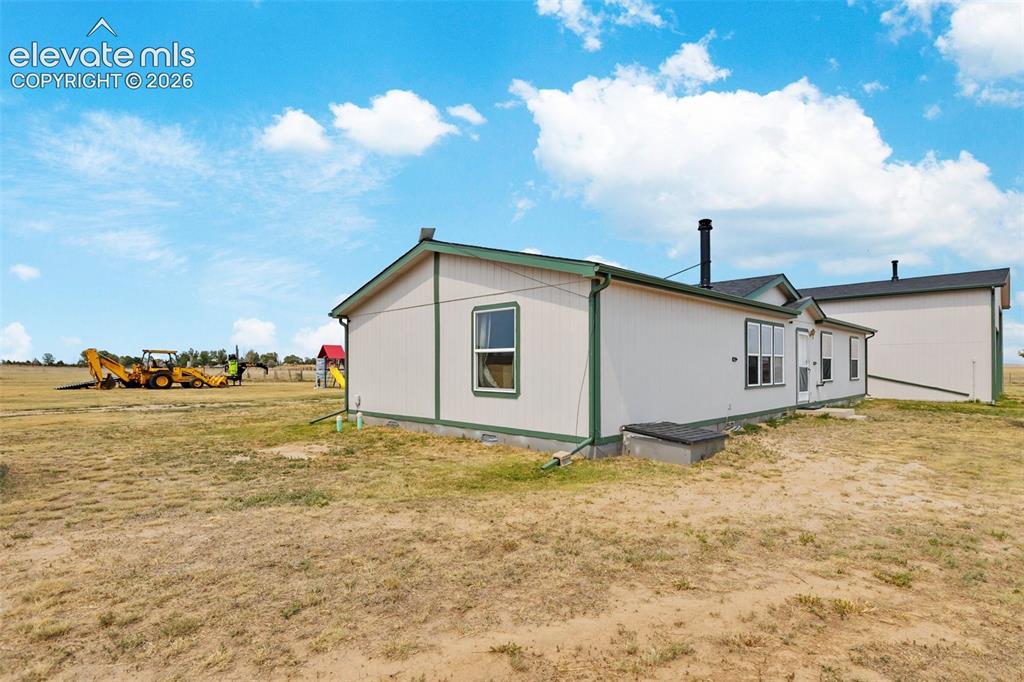 Image 43 of 45: Single-story property with light-colored siding and dark green trim, featur