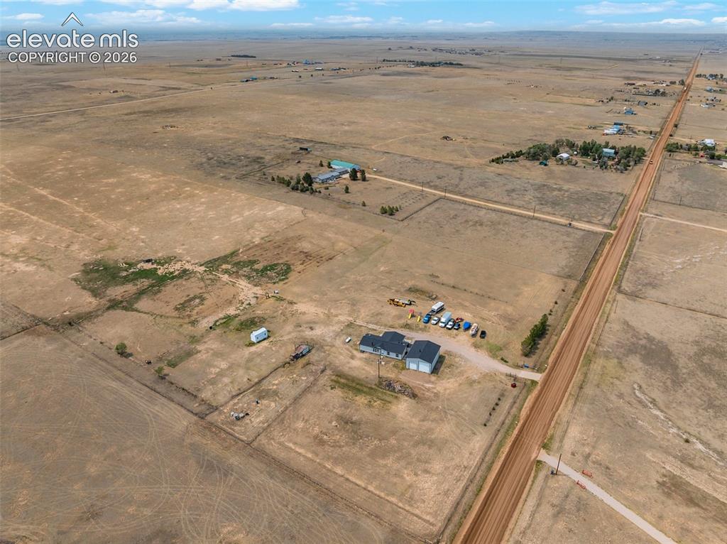 Image 7 of 45: Expansive rural property featuring a main residence with a dark gray roof,