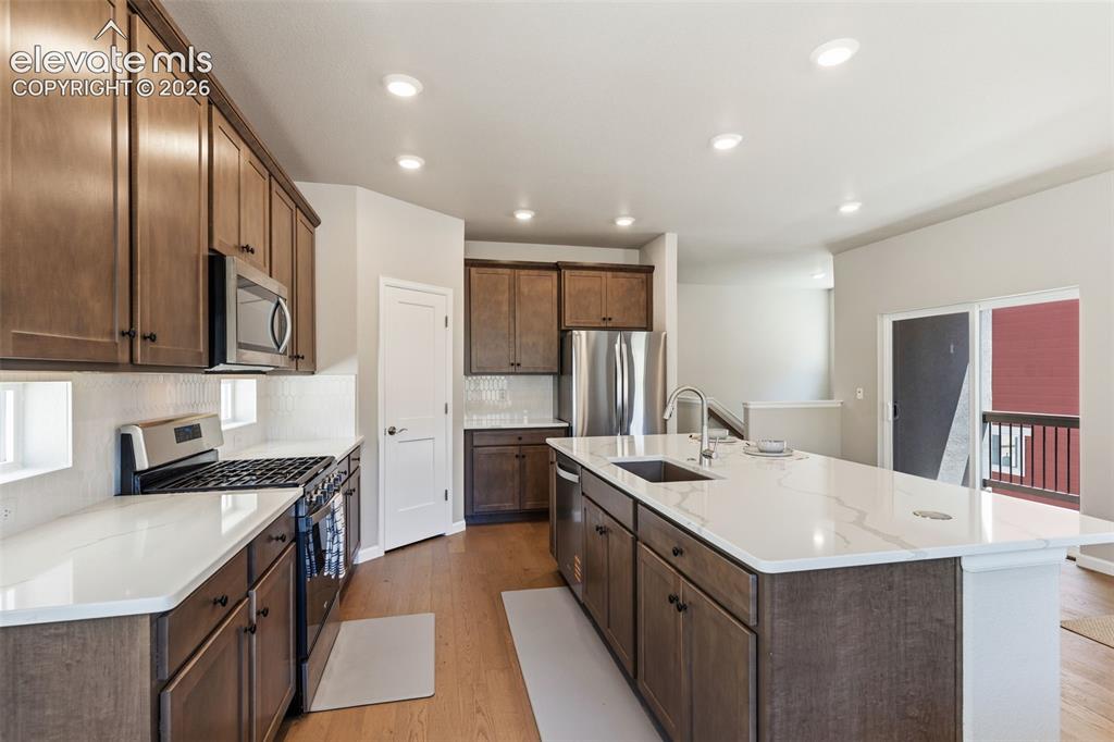 Image 10 of 41: Modern kitchen featuring an expansive center island with an undermount sink