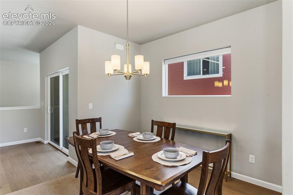 Image 17 of 41: Dining area featuring wood-finish flooring, a contemporary ceiling light fi