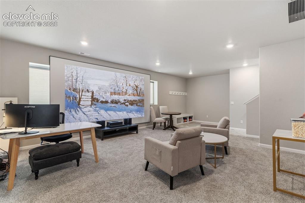 Image 33 of 41: Spacious living area featuring a large projector screen, recessed lighting,