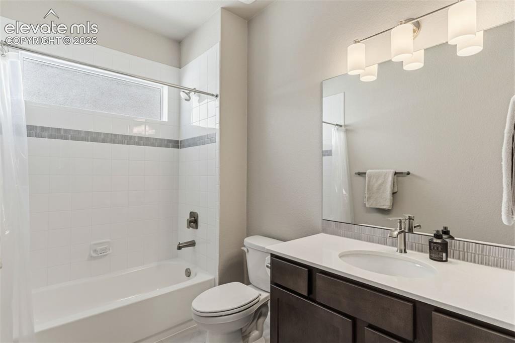 Image 35 of 41: Bathroom featuring a white bathtub with subway tile surround, accent tile b