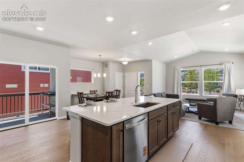 Image 7 of 41: Open-concept living area featuring wood-finish flooring, a kitchen island w