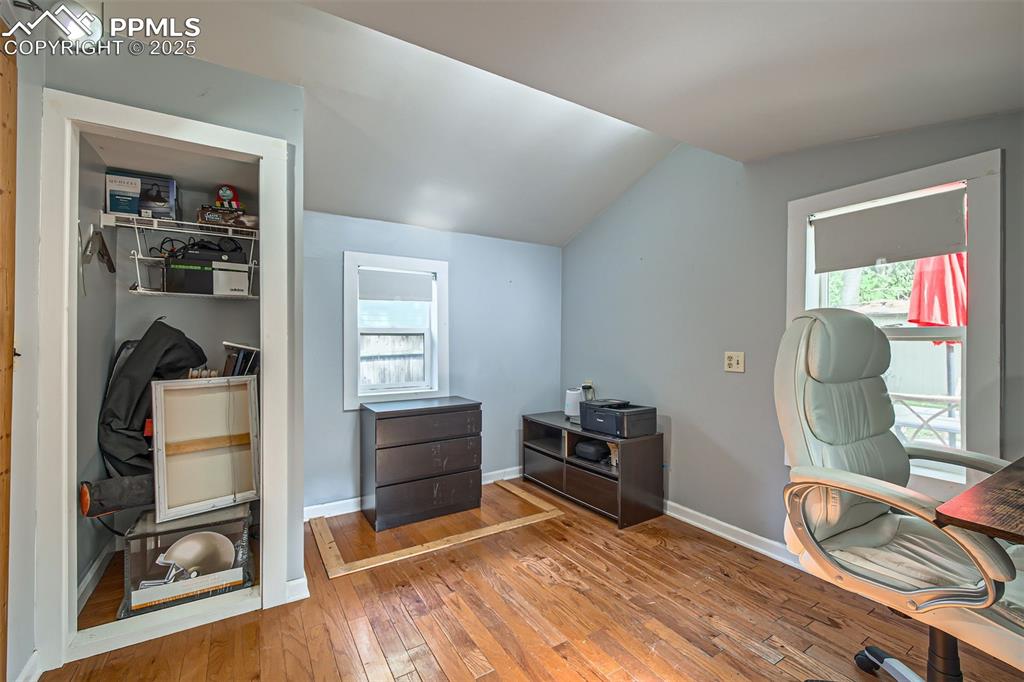 Image 15 of 20: Bedroom with vaulted ceiling, hardwood / wood-style flooring, and baseboard