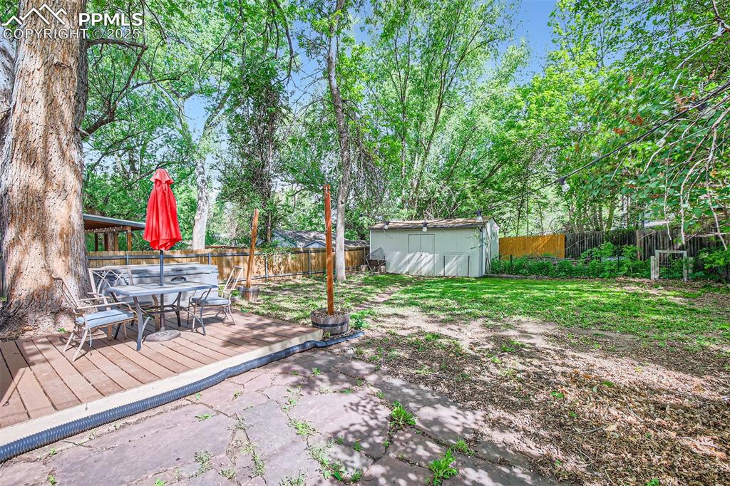 Image 17 of 20: View of yard featuring outdoor dining space and a wooden deck