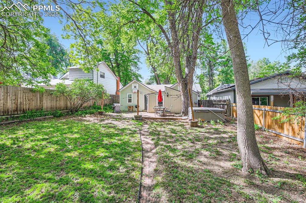 Image 19 of 20: Fenced backyard featuring a hot tub and a patio area