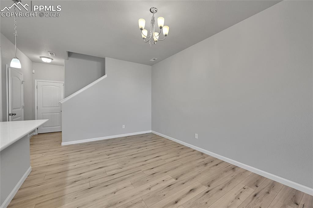 Image 11 of 46: Unfurnished dining area featuring light wood-style floors and a chandelier