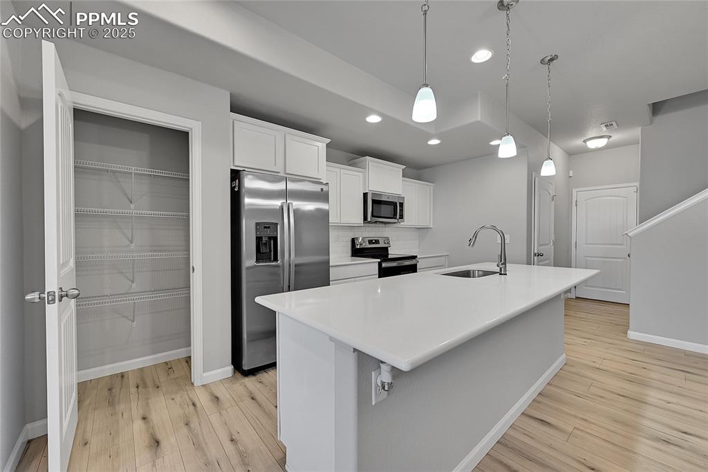Image 13 of 46: Kitchen featuring stainless steel appliances, white cabinets, recessed ligh