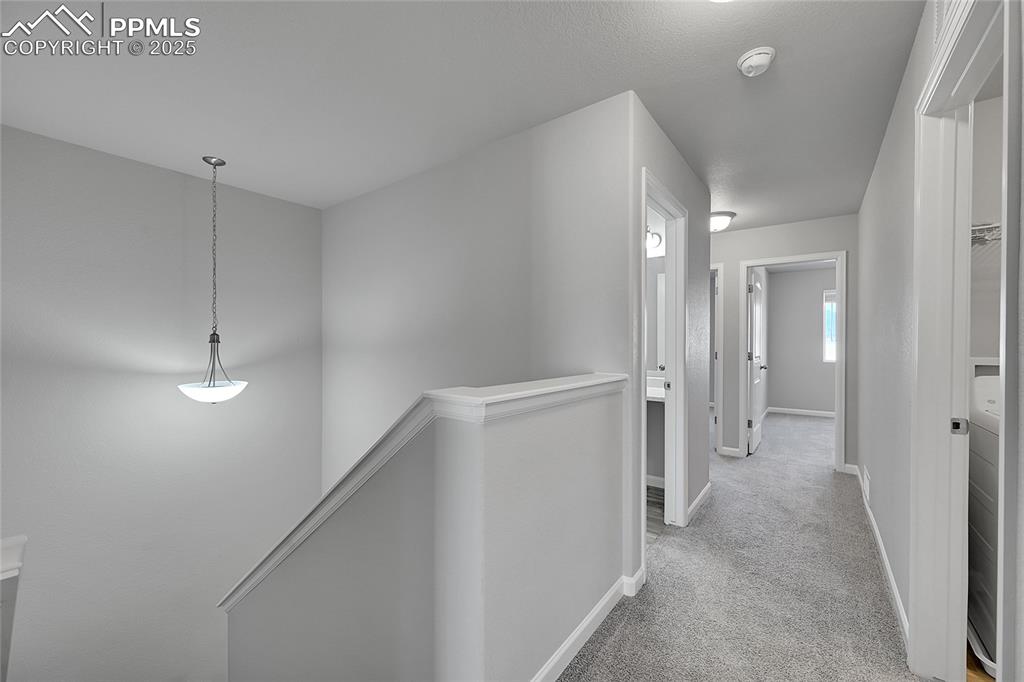 Image 20 of 46: Hall featuring an upstairs landing and light colored carpet