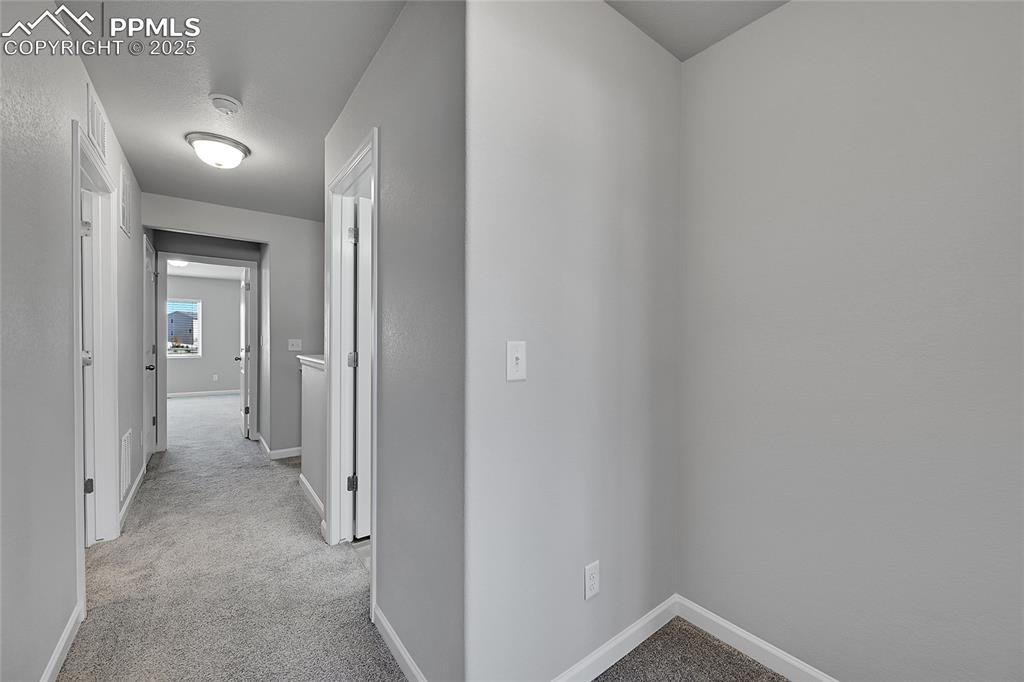 Image 21 of 46: Hallway featuring light colored carpet and baseboards