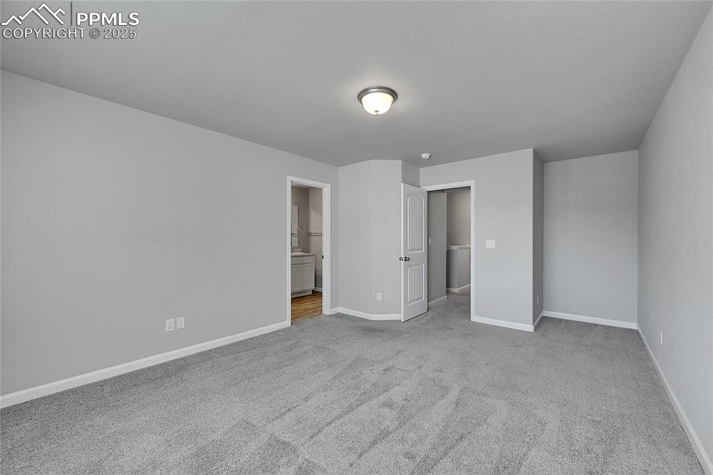 Image 24 of 46: Unfurnished bedroom with light colored carpet and ensuite bath