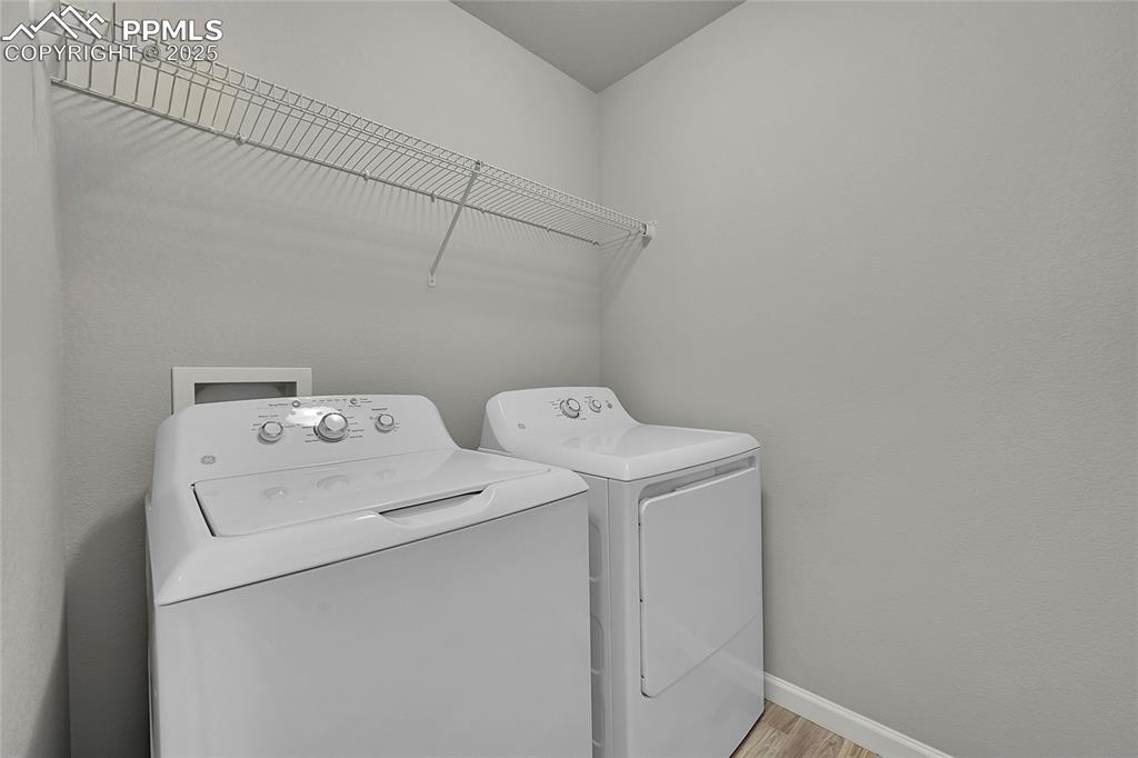 Image 28 of 46: Laundry room with light wood-style floors and independent washer and dryer