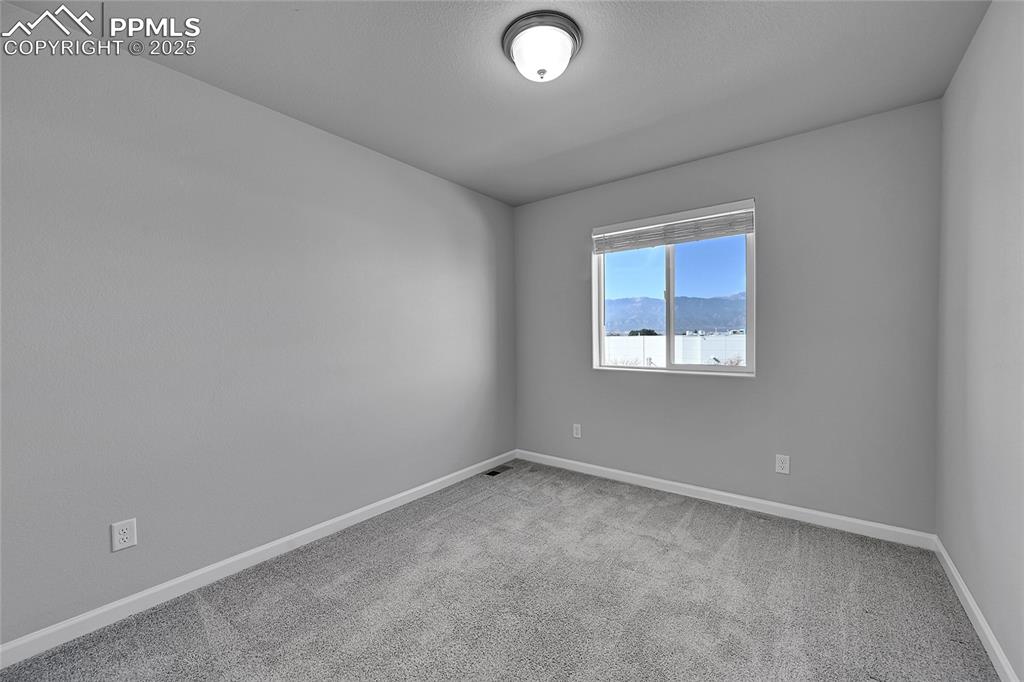 Image 29 of 46: Unfurnished room with light colored carpet and a mountain view