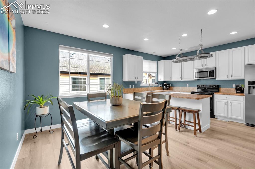 Image 10 of 39: Living room featuring a stone fireplace, light wood-type flooring, a ceilin