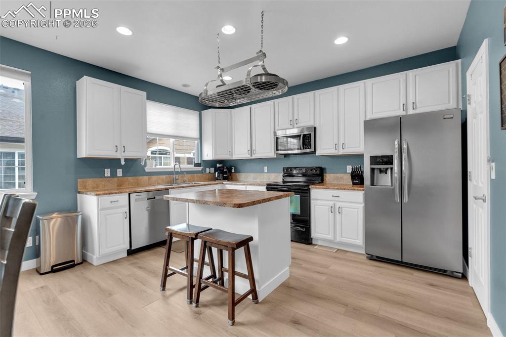 Image 11 of 39: Dining room featuring light wood finished floors and recessed lighting