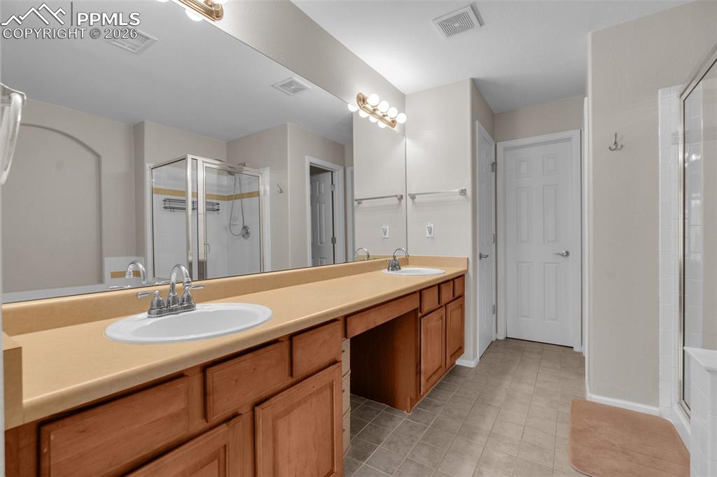 Image 21 of 39: Bedroom featuring a desk, light colored carpet, a ceiling fan, ensuite bath