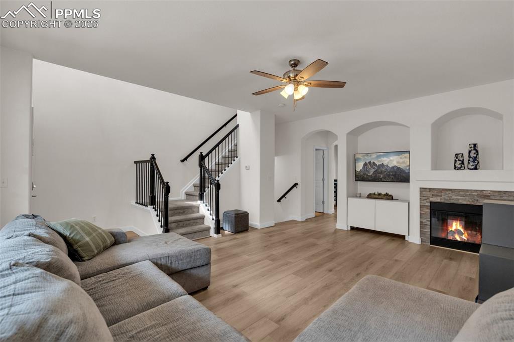 Image 7 of 39: Living area featuring light wood-style flooring, arched walkways, a ceiling
