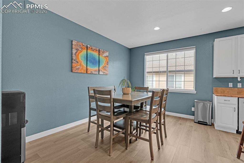 Image 8 of 39: Living area with light wood-type flooring and ceiling fan
