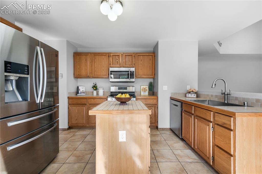 Image 14 of 50: Kitchen with newer stainless steel applicants, island, pantry and walk out