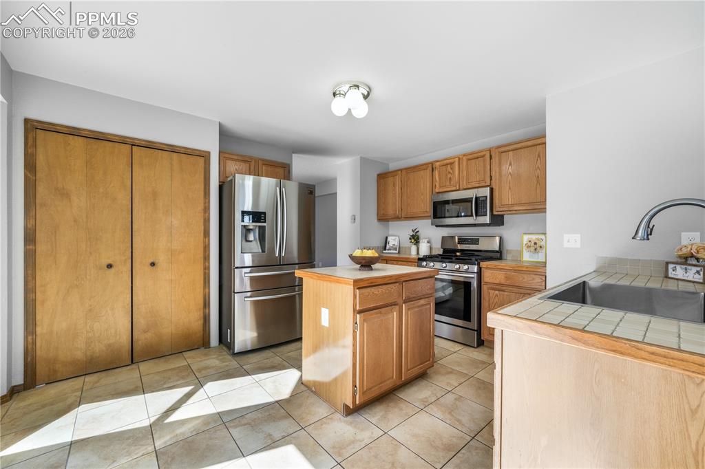 Image 15 of 50: Kitchen with newer stainless steel applicants, island, pantry and walk out