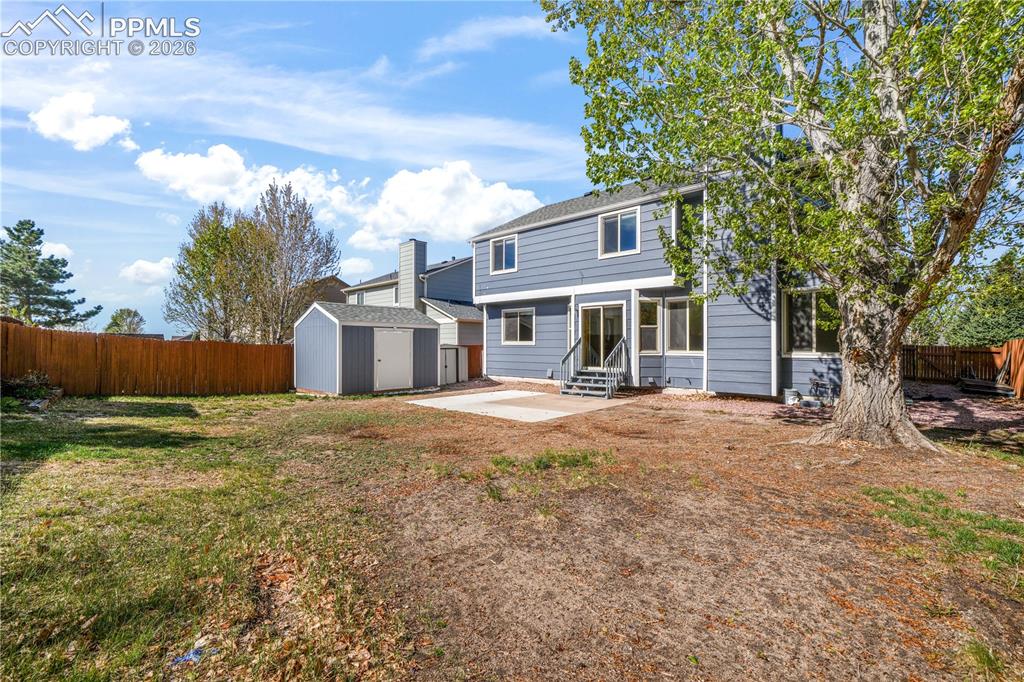 Image 47 of 50: Back yard with privacy fence and storage sheds