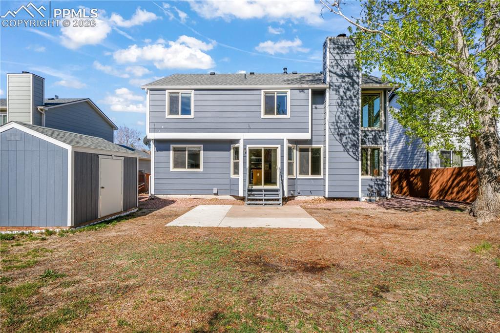 Image 48 of 50: Back yard with privacy fence and storage sheds