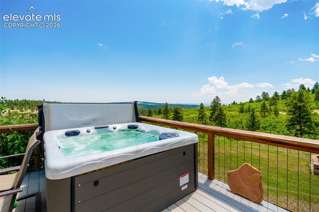 Image 34 of 50: Wraparound deck with hot tub access from primary suite photographed June 20