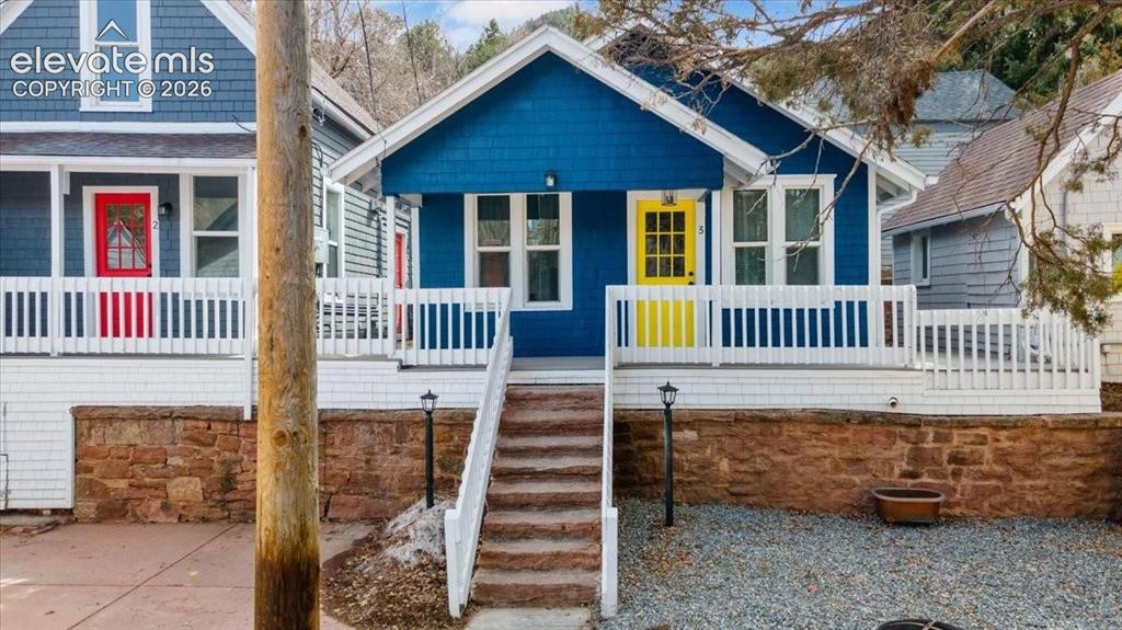 Image 20 of 39: Cottage 3 with bright yellow door
