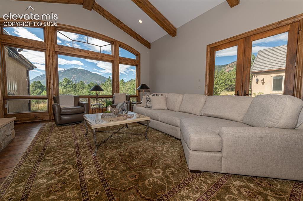 Image 15 of 50: Great room area with heart pine plank floors and beamed ceiling
