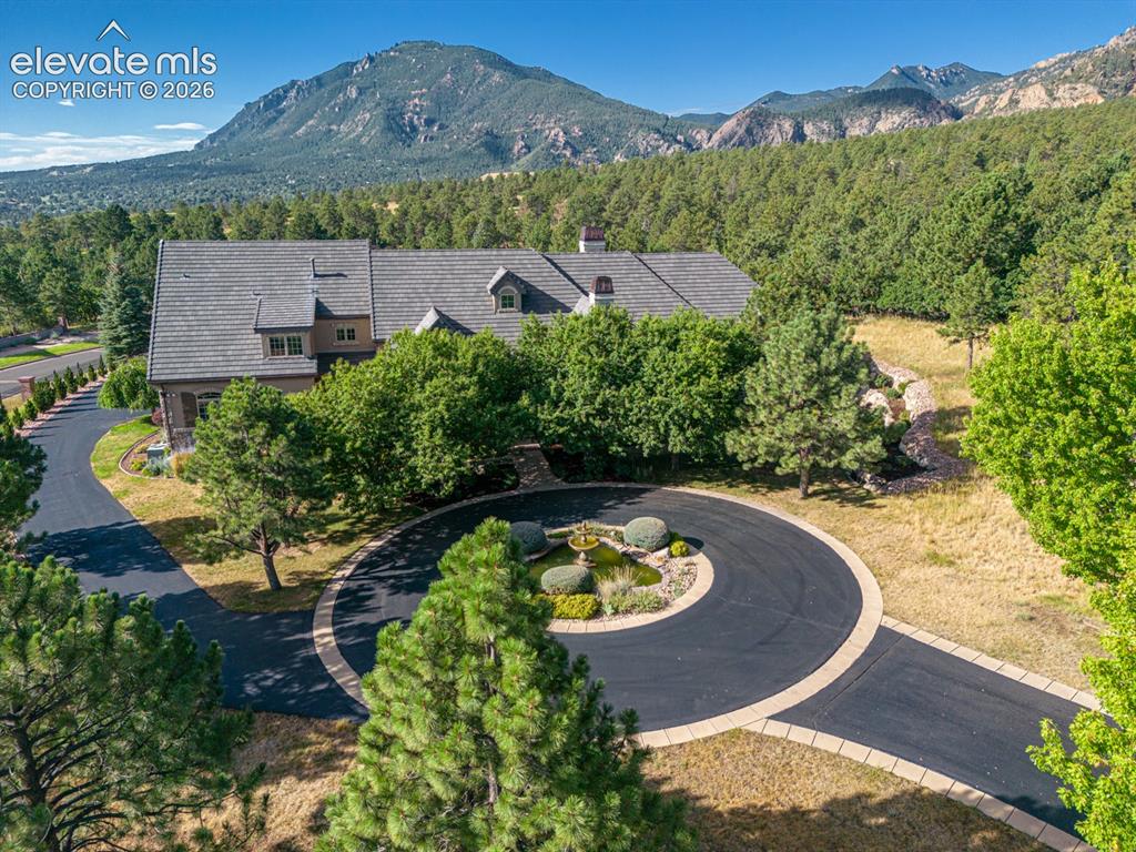 Image 2 of 50: Front of the home features circular driveway with fountain to greet guests.