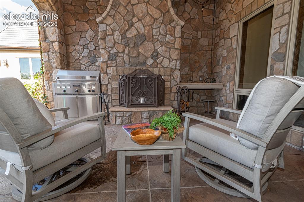 Image 22 of 50: Wood burning fireplace on veranda