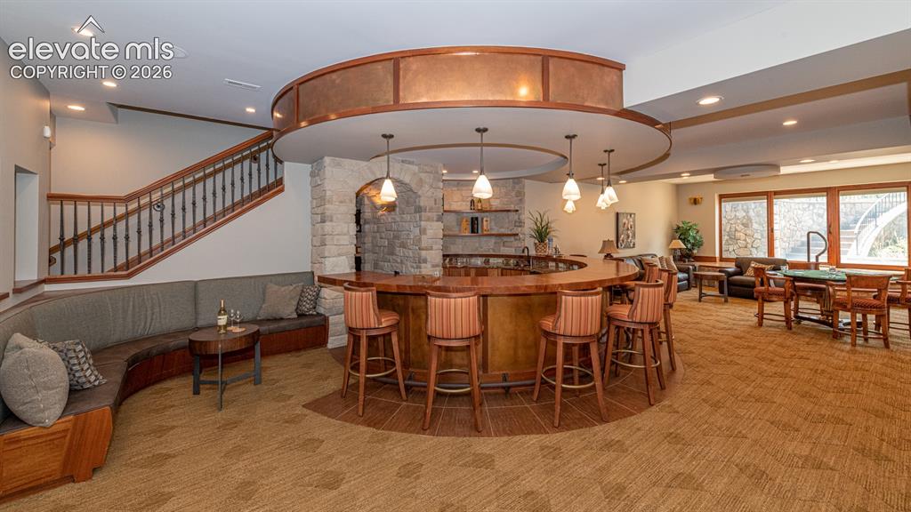 Image 42 of 50: Basement rec room with custom bar