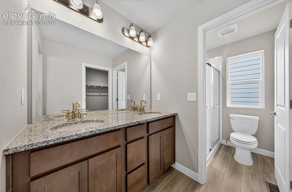 Image 22 of 33: Dual vanity with granite countertop and gold-tone fixtures