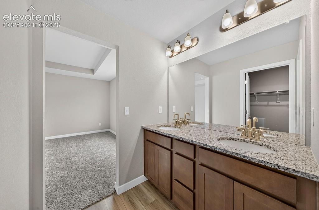 Image 24 of 33: Dual vanity with granite countertop, undermount sinks, and wood-finish cabi