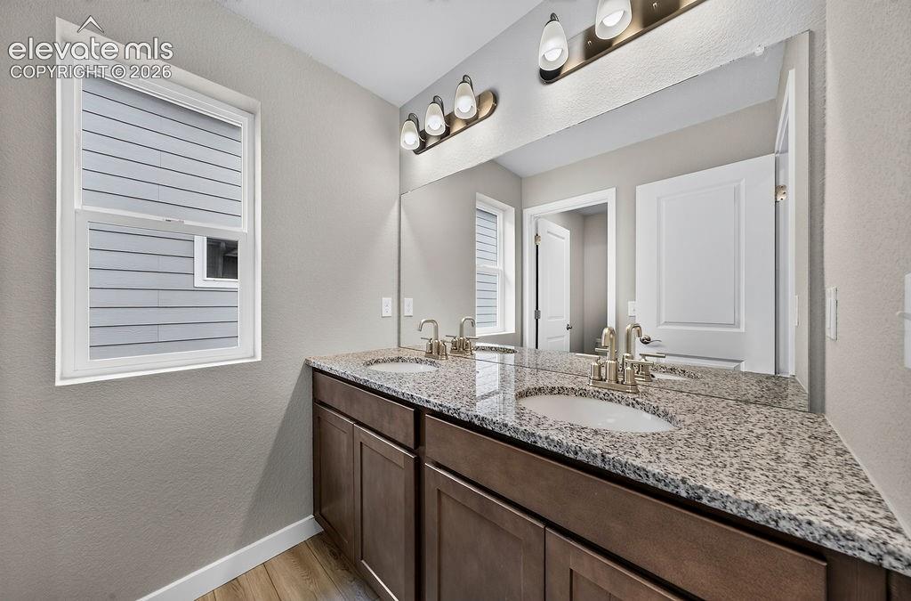 Image 27 of 33: Dual vanity with undermount sinks, granite countertops, and brushed nickel