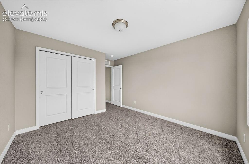 Image 30 of 33: Neutral-toned walls, carpeted flooring, and white trim