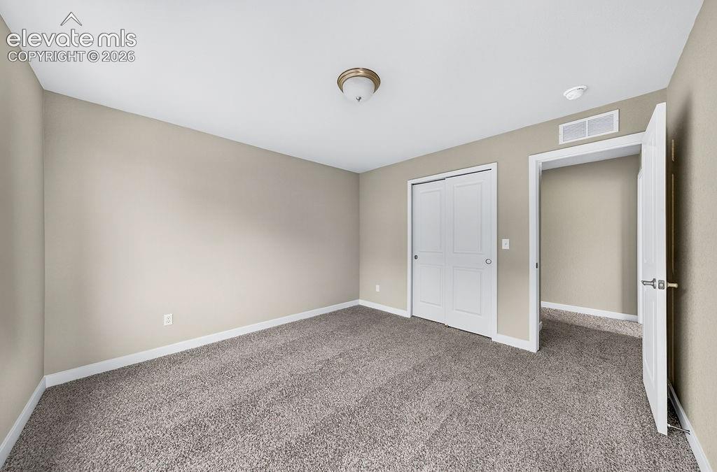 Image 33 of 33: Neutral wall tones, gray carpeting, white baseboards, a white two-panel clo