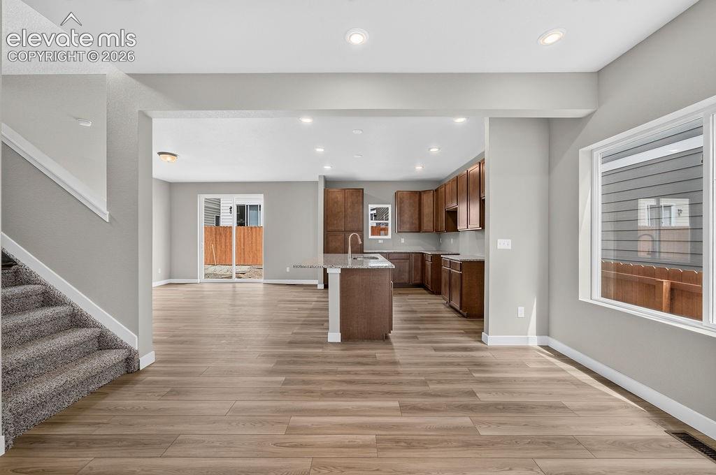 Image 7 of 33: Wood-finish flooring throughout the main living areas, a kitchen island wit