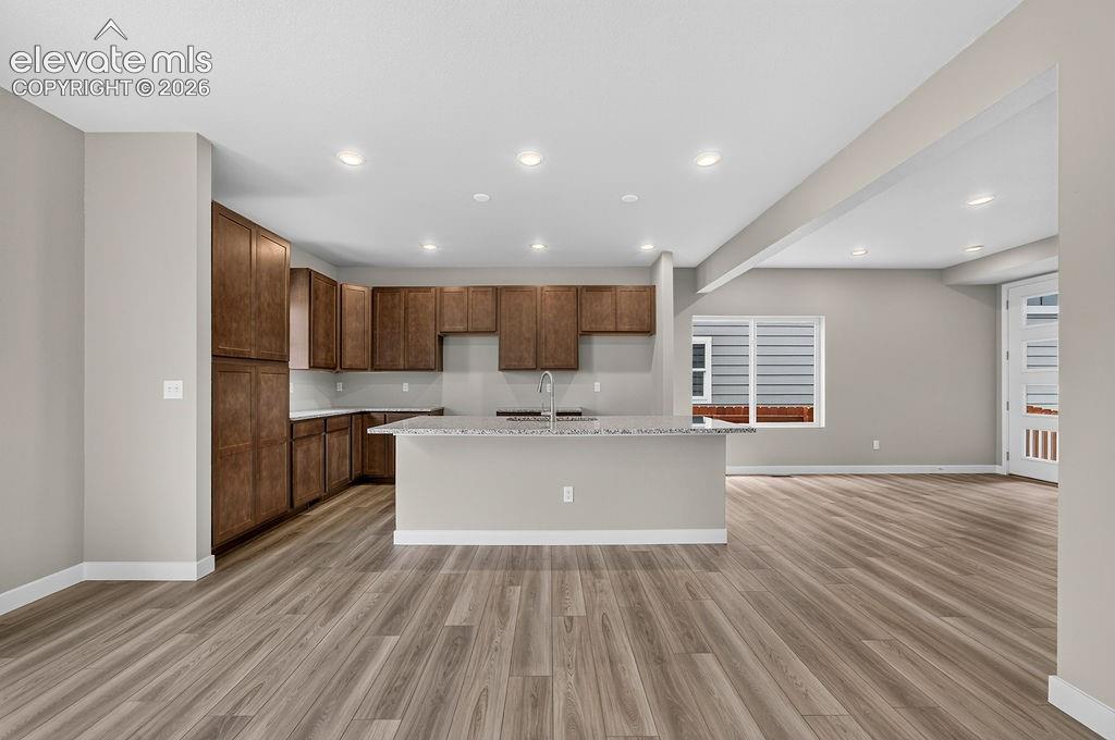 Image 8 of 33: Spacious kitchen featuring wood cabinetry, light-toned countertops, and a c