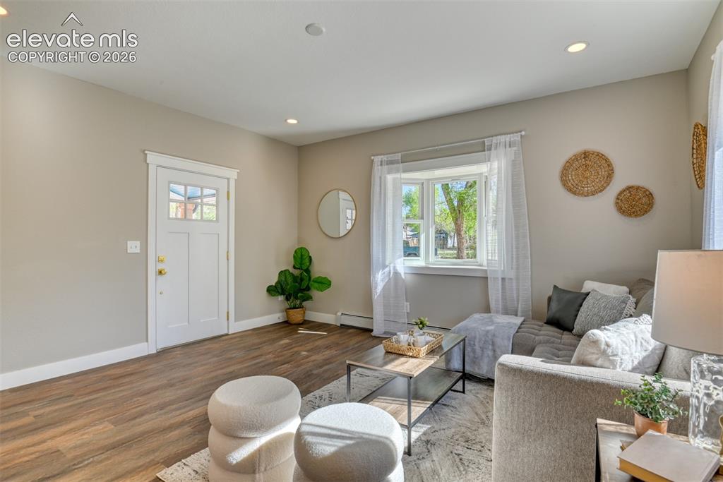 Image 10 of 47: Inviting living space featuring wood-finish flooring, recessed lighting, an
