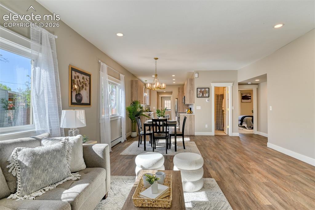 Image 11 of 47: Open-concept living area with wood-finish flooring, recessed lighting, and 