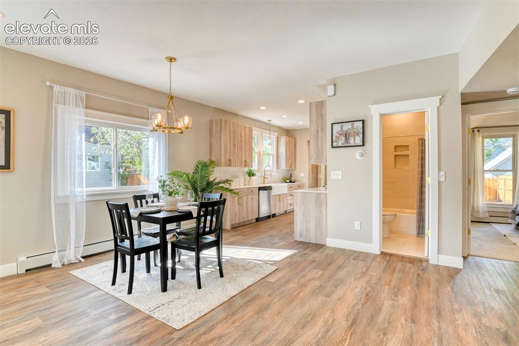 Image 12 of 47: Open-concept living space featuring wood-finish flooring and a contemporary