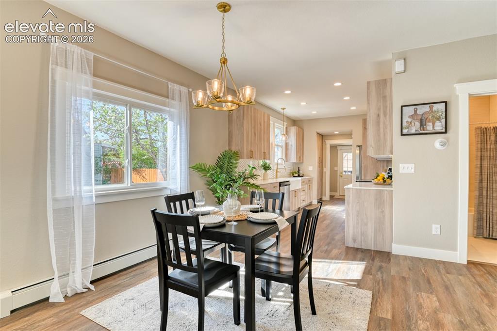 Image 13 of 47: Open-concept dining area featuring wood-finish flooring, a contemporary cha