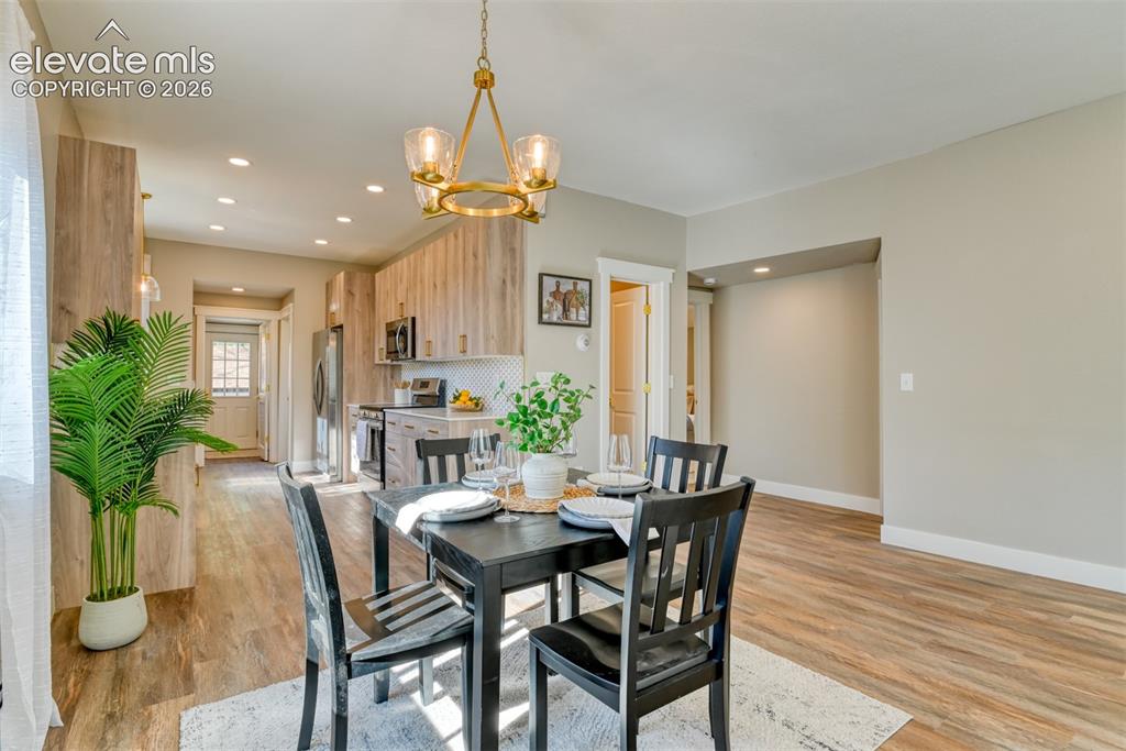 Image 14 of 47: Open-concept dining area featuring wood-finish flooring, recessed lighting,