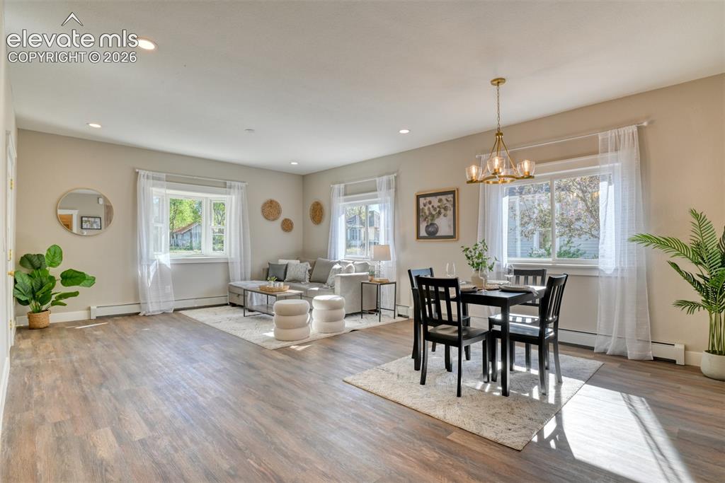 Image 16 of 47: Spacious open-concept living area featuring wood-finish flooring, recessed 
